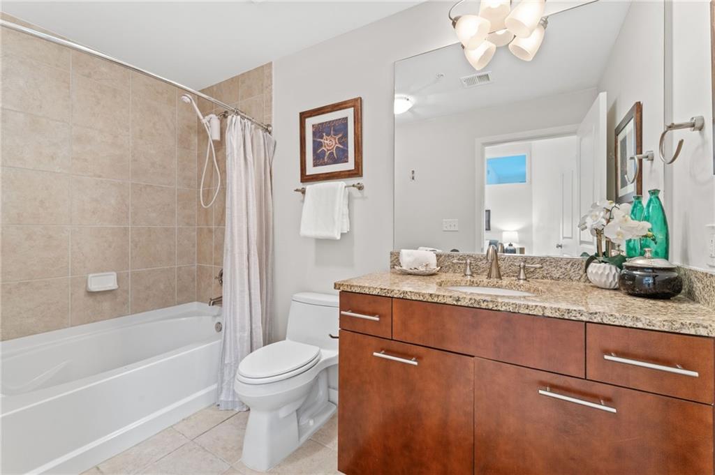 3300 Windy Ridge Parkway Southeast, Unit 809 Atlanta, GA 30339 - Photo 12 of 30 a bathroom with a granite countertop sink a toilet and bathtub