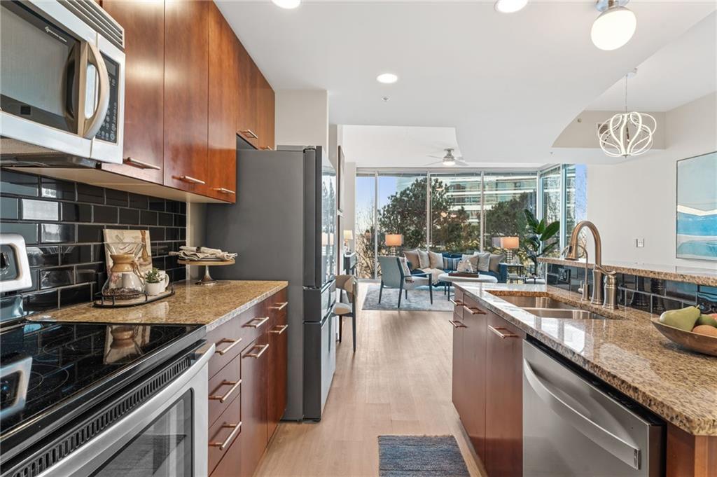 3300 Windy Ridge Parkway Southeast, Unit 809 Atlanta, GA 30339 - Photo 4 of 30 a kitchen with stainless steel appliances granite countertop a sink stove and refrigerator