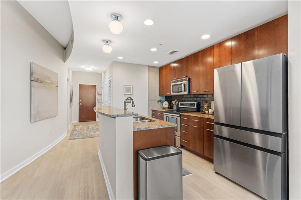 3300 Windy Ridge Parkway Southeast, Unit 809 Atlanta, GA 30339 - Photo 5 of 30 a kitchen with stainless steel appliances granite countertop a refrigerator and a stove top oven
