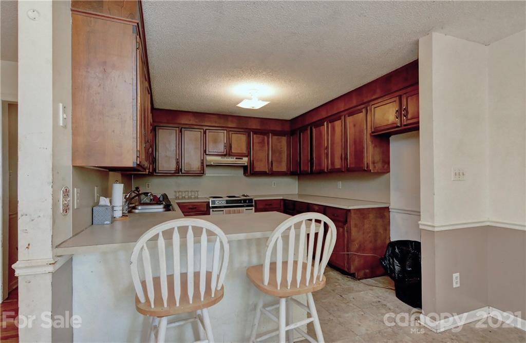 3621 Austin Road Monroe, NC 28112 - Photo 13 of 28 a kitchen with stainless steel appliances granite countertop a sink a stove a refrigerator cabinets and chairs