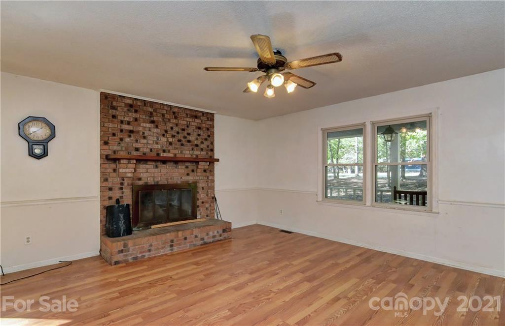 3621 Austin Road Monroe, NC 28112 - Photo 17 of 28 a view of a livingroom with a fireplace a ceiling fan and wooden floor