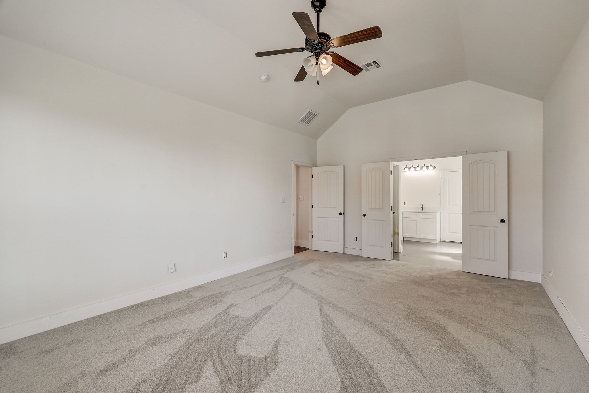16012 Spillman Ranch Loop Austin, TX 78738 - Photo 21 of 38 Discover a spacious primary bedroom offering vaulted ceilings and plush carpet, with an en suite bathroom.