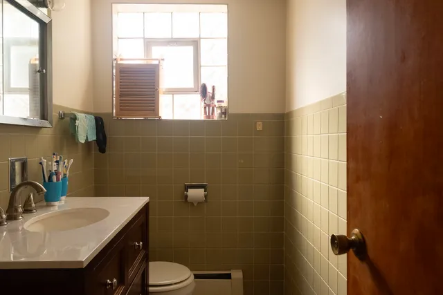 a bathroom with a sink toilet and window