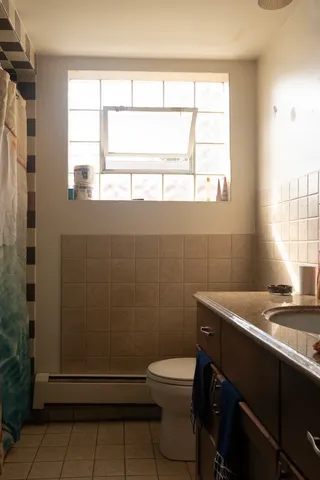 a bathroom with a sink a toilet and a window