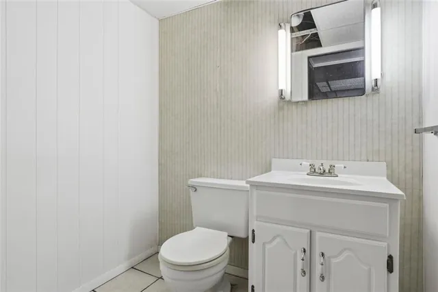 a bathroom with a toilet a sink a mirror and vanity