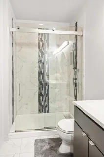 a bathroom with a shower a toilet and a shower