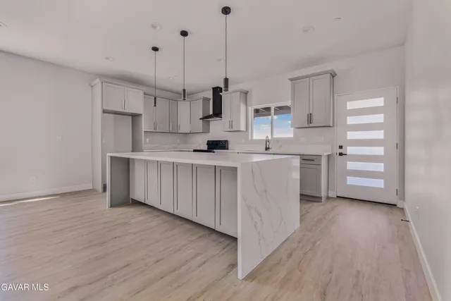 a kitchen with kitchen island white cabinets and stainless steel appliances