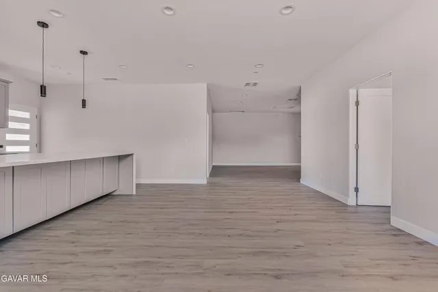 a view of an empty room with wooden floor