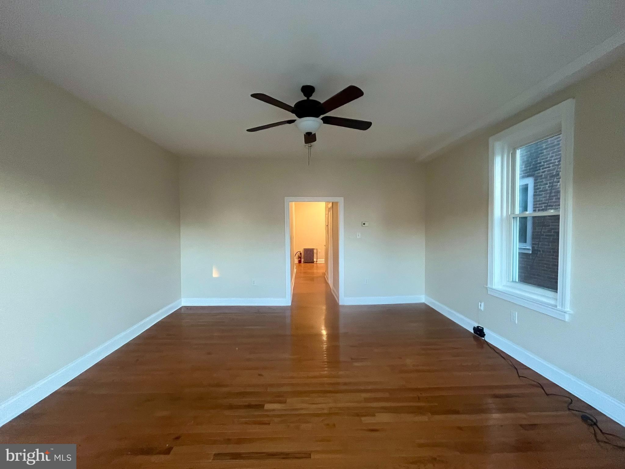 4946 Walnut Street, Unit 2F Philadelphia, PA 19139 - Photo 3 of 20 wooden floor in an empty room with a window