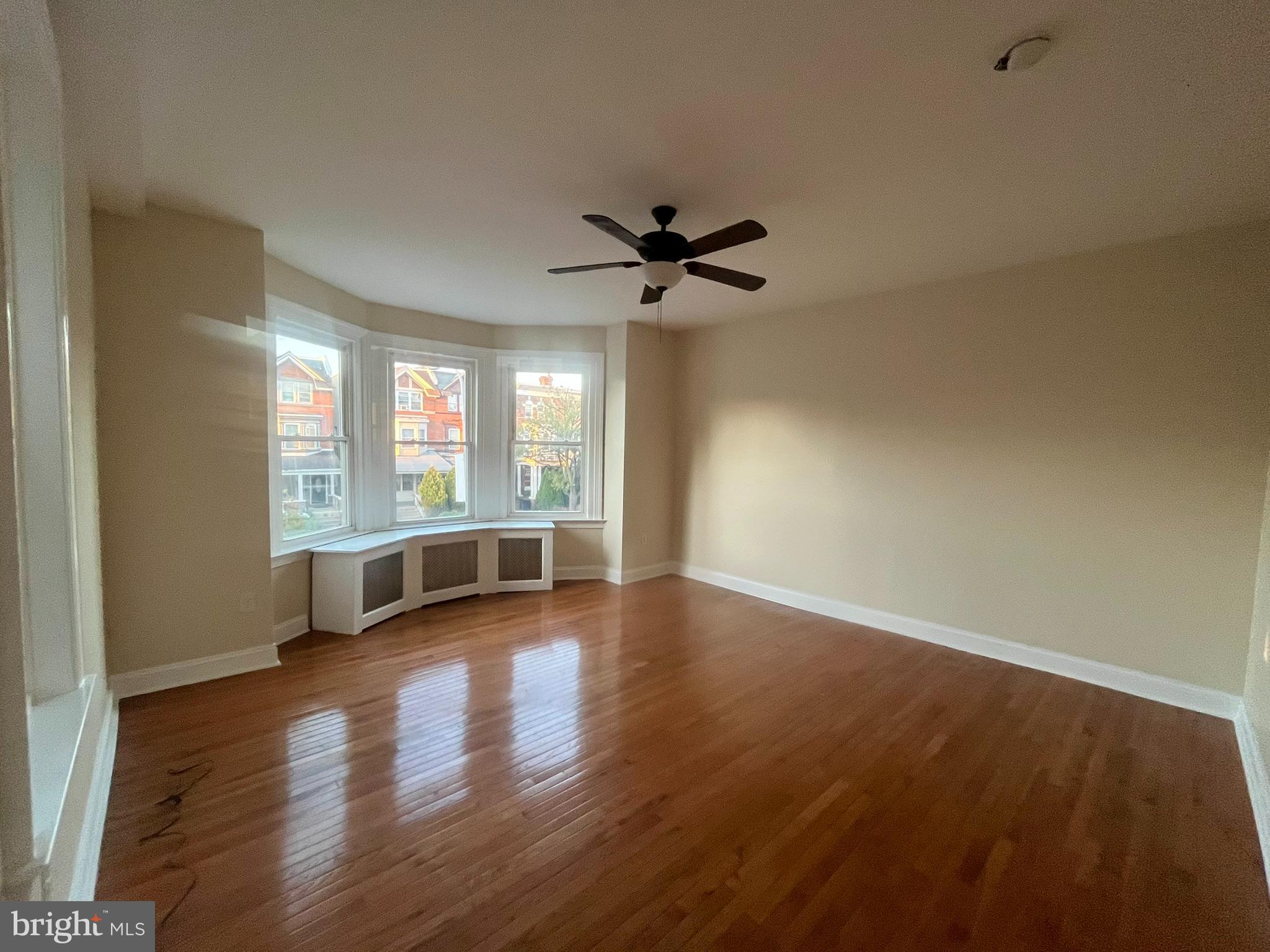 4946 Walnut Street, Unit 2F Philadelphia, PA 19139 - Photo 4 of 20 an empty room with wooden floor and windows