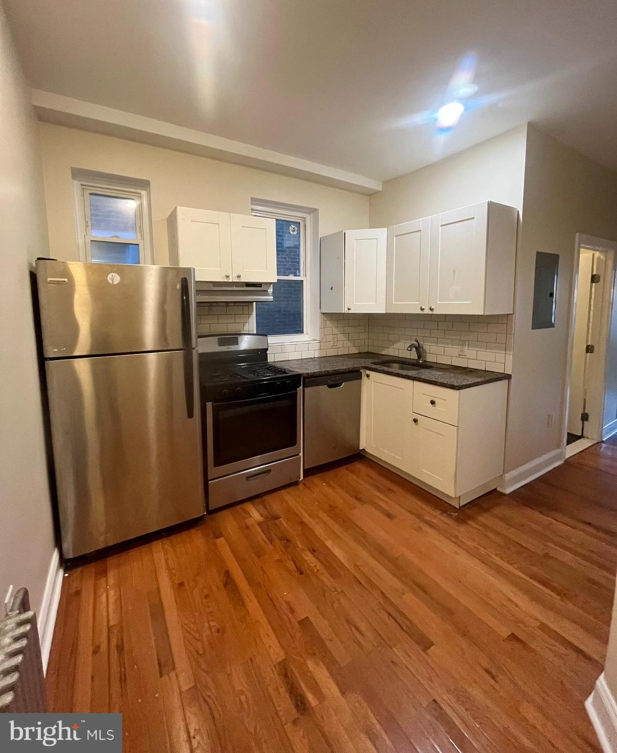 4946 Walnut Street, Unit 2F Philadelphia, PA 19139 - Photo 5 of 20 a kitchen with granite countertop a refrigerator and a stove top oven
