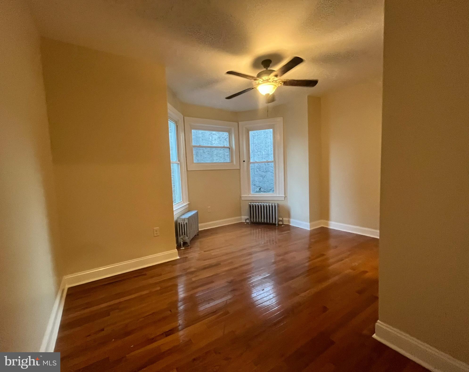 4946 Walnut Street, Unit 2F Philadelphia, PA 19139 - Photo 9 of 20 a view of empty room with wooden floor and fan