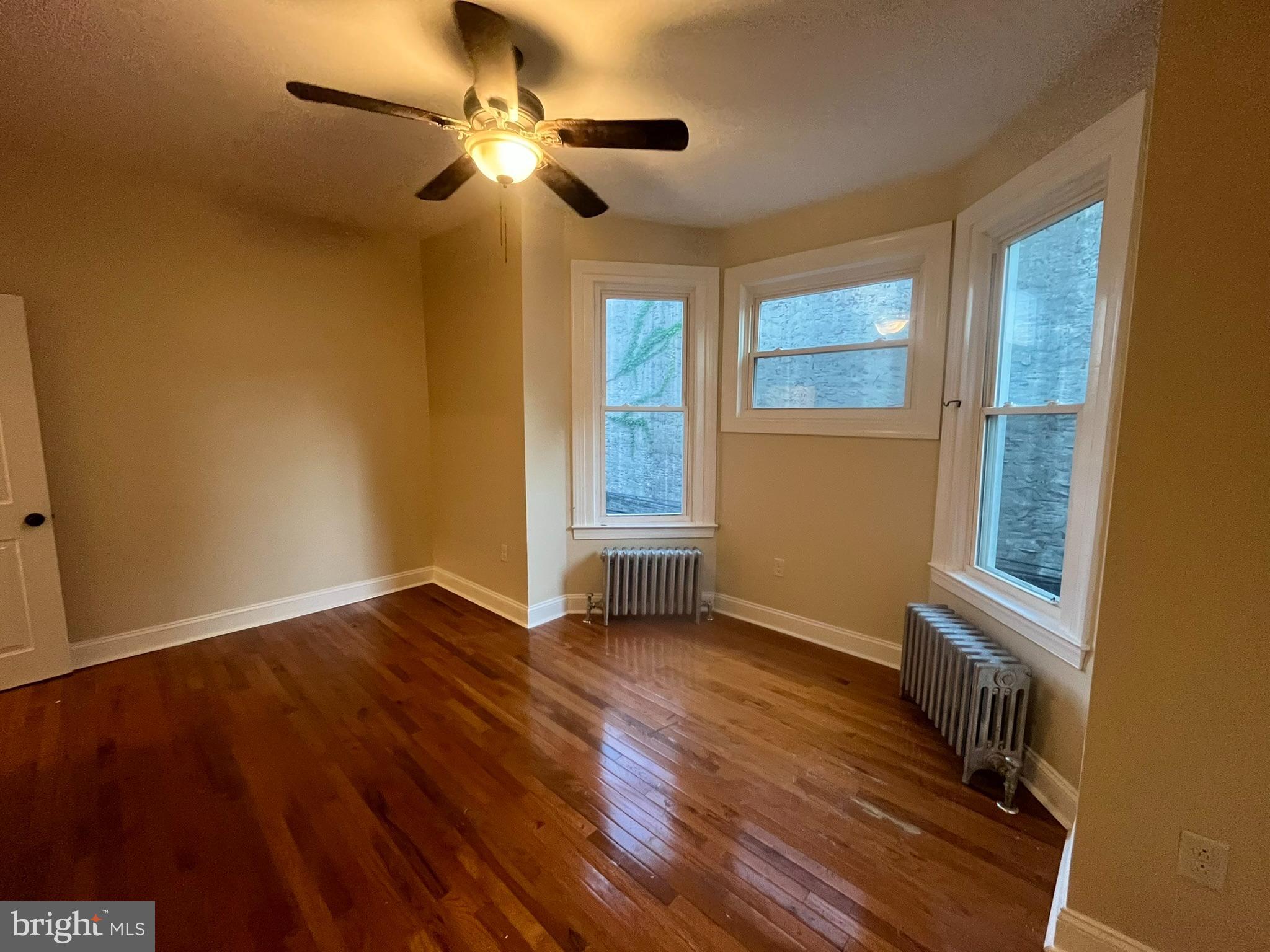 4946 Walnut Street, Unit 2F Philadelphia, PA 19139 - Photo 10 of 20 a view of an empty room with a window and wooden floor