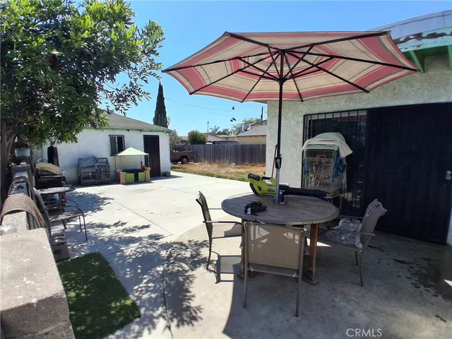 a patio with a table and chairs under an umbrella
