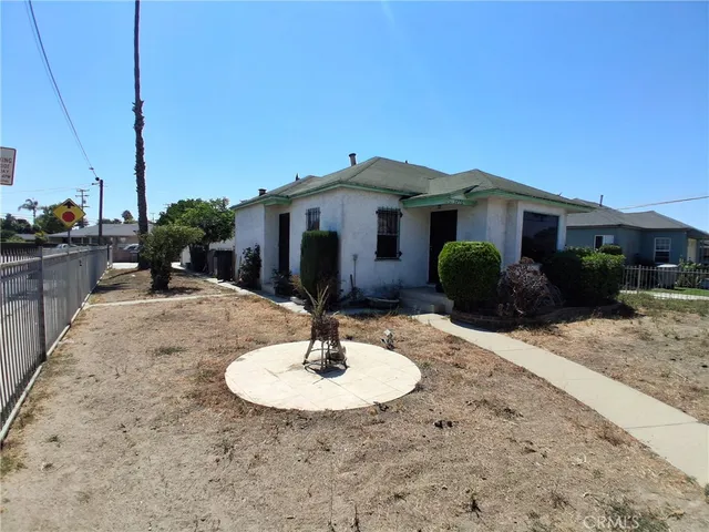 a view of a house with backyard water fountain and sitting area