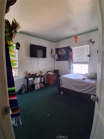 a bedroom with furniture and a flat screen tv