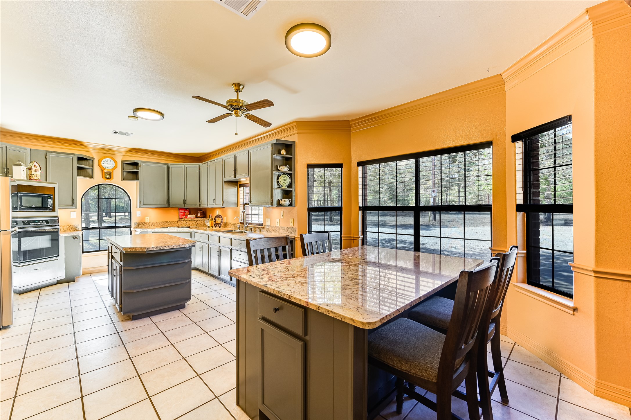 486 Westwood Road Lockhart, TX 78644 - Photo 11 of 29 Kitchen featuring open shelves, a center island, light tile floors, light stone/granite & formica counters, and gray cabinetry