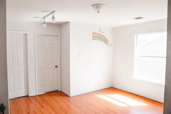 a view of an empty room with wooden floor
