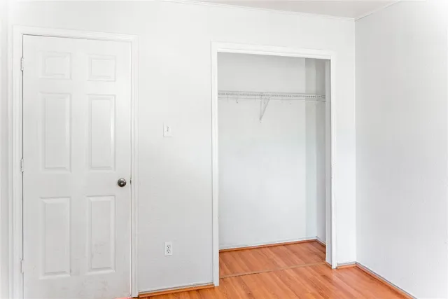 a view of a room with a window and wooden floor