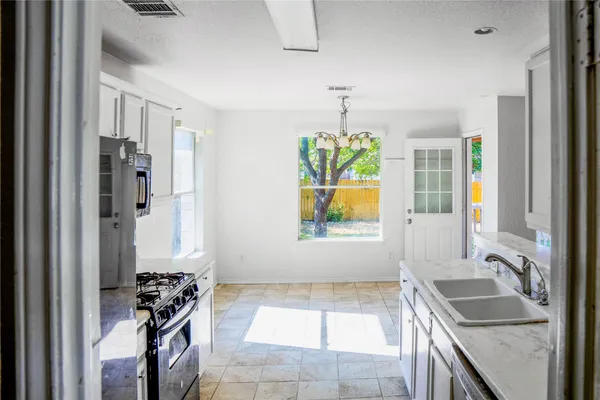 a kitchen with a stove a refrigerator and a sink