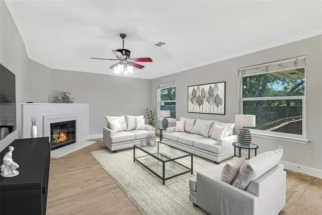 a living room with furniture a large window and a fireplace