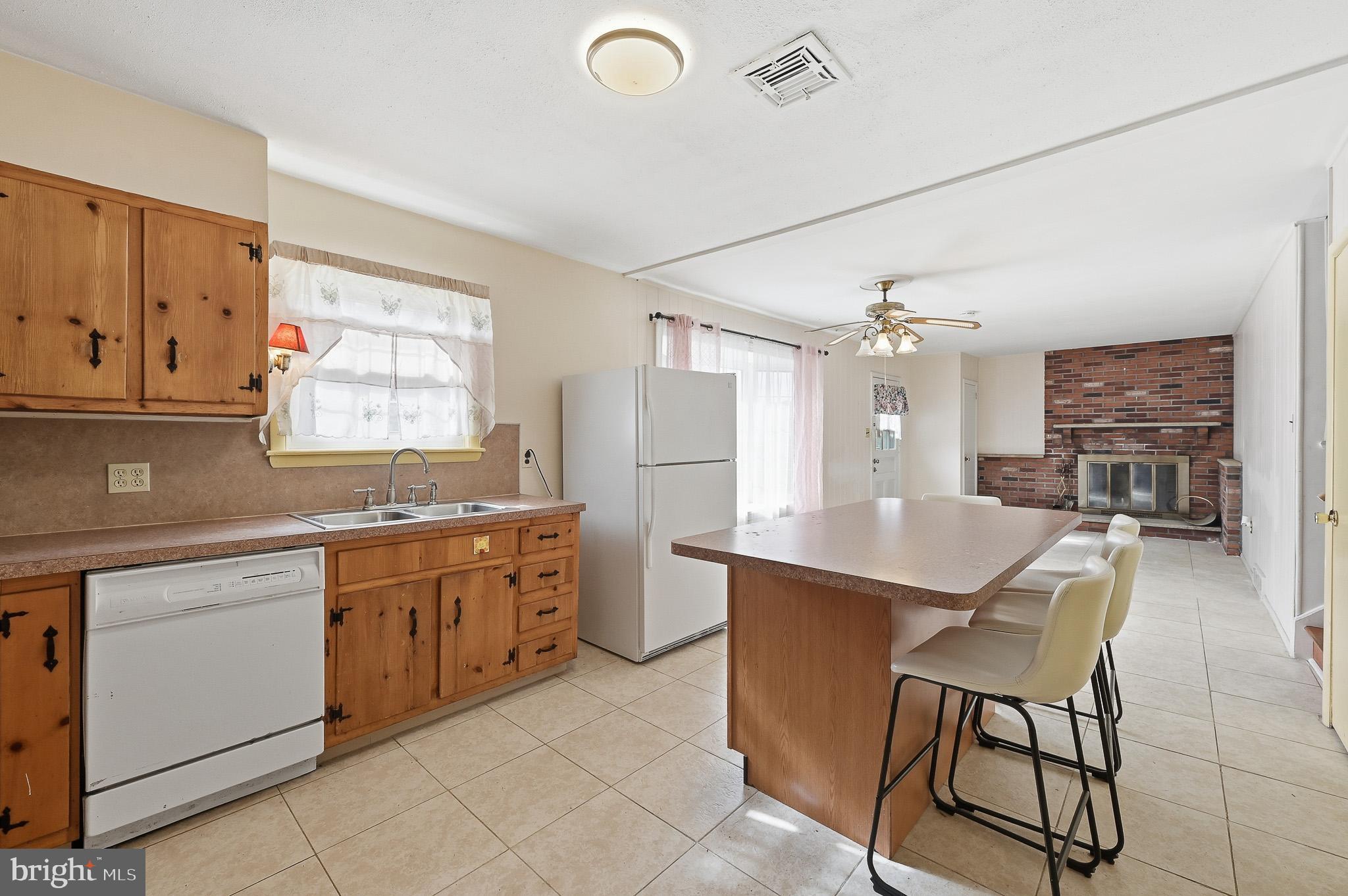 406 Blackstone Road Newark, DE 19713 - Photo 10 of 27 a large kitchen with kitchen island stainless steel appliances a table chairs sink and cabinets