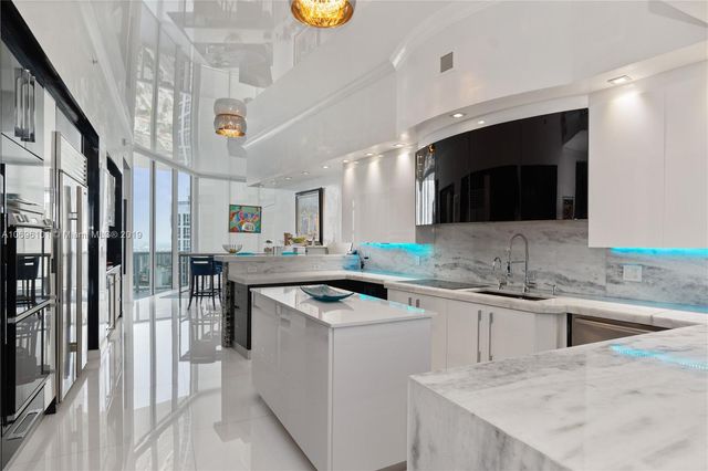 a kitchen that has a sink a stove and chairs