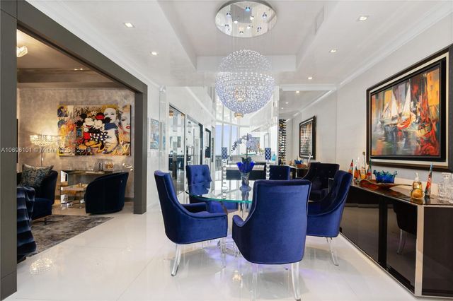 a view of a dining room with furniture a kitchen and chandelier