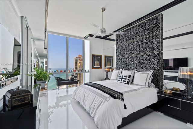 a bedroom with a bed a flat screen tv and a couch