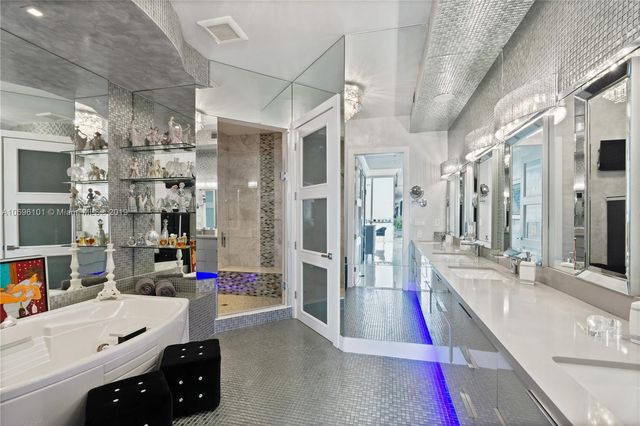 a large white kitchen with lots of counter top space and stainless steel appliances