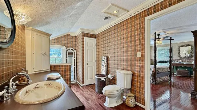 a living room with a bed and wooden floor