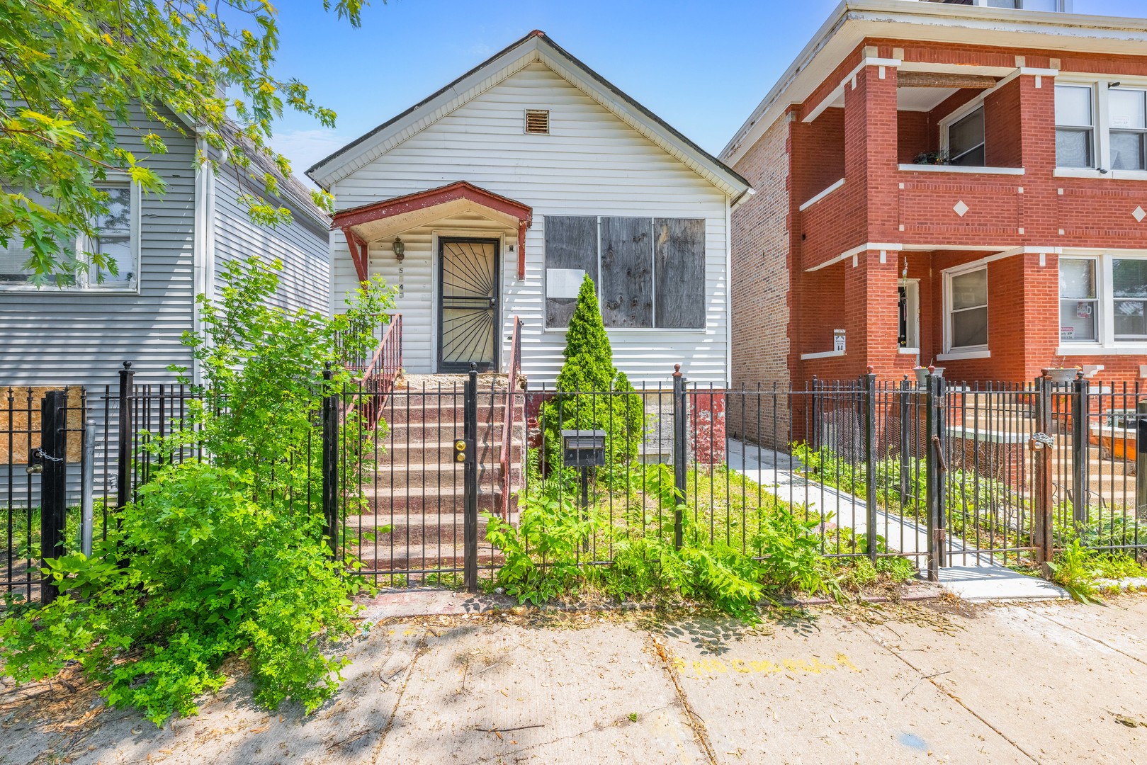 5247 South May Street Chicago, IL 60609 - Photo 1 of 23 a front view of a house with a garden