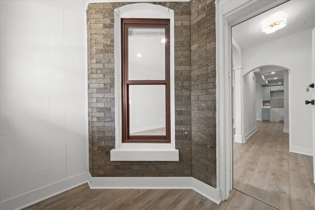 a view of an empty room with window and wooden floor