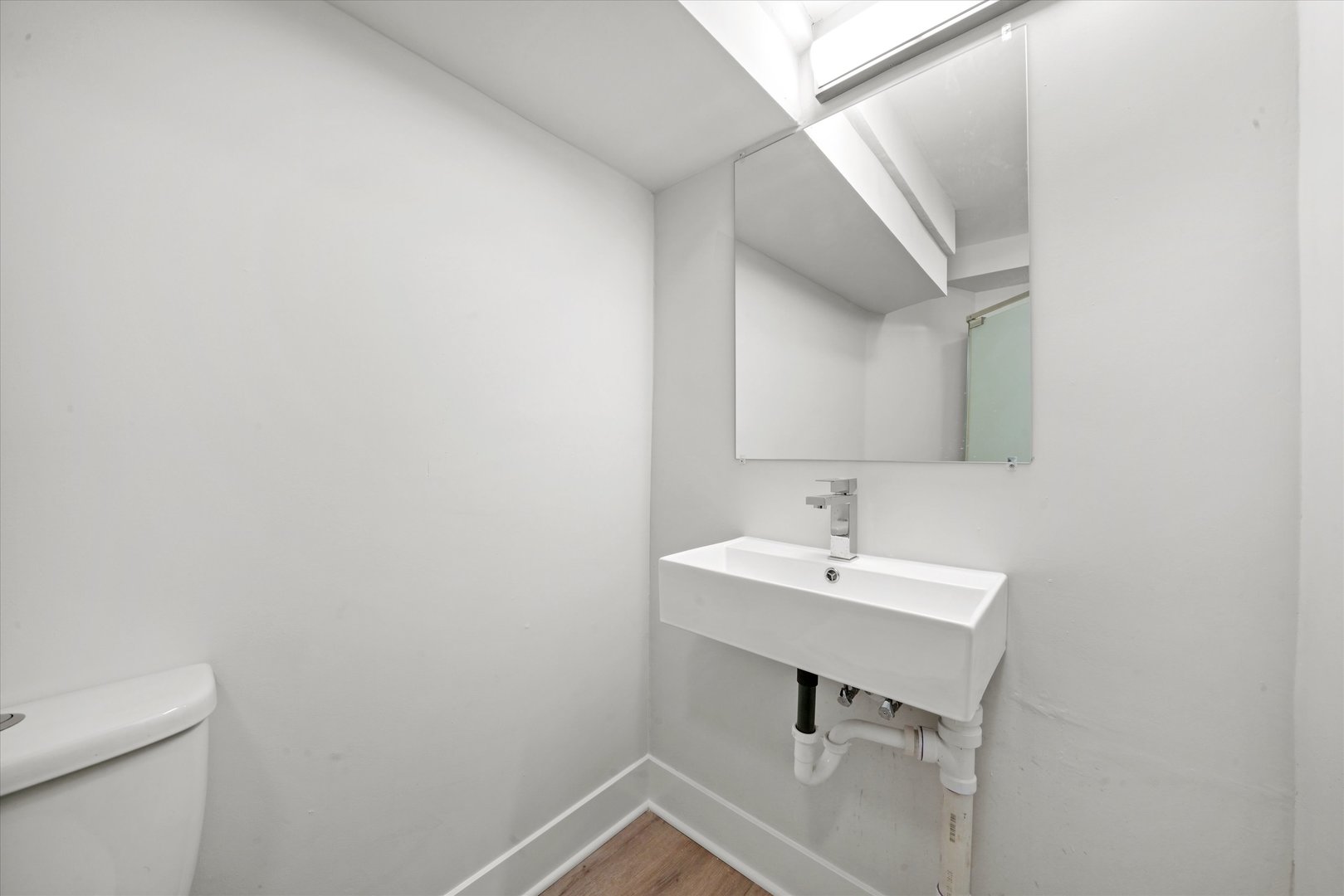 7356 South Kenwood Avenue Chicago, IL 60619 - Photo 22 of 27 a bathroom with a sink a toilet and mirror