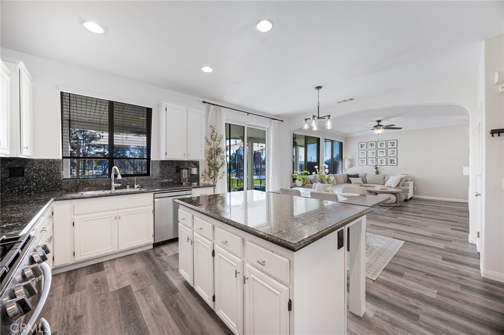 33345 Wallace Way Yucaipa, CA 92399 - Photo 14 of 38 a kitchen with granite countertop a sink stove cabinets dining table and chairs