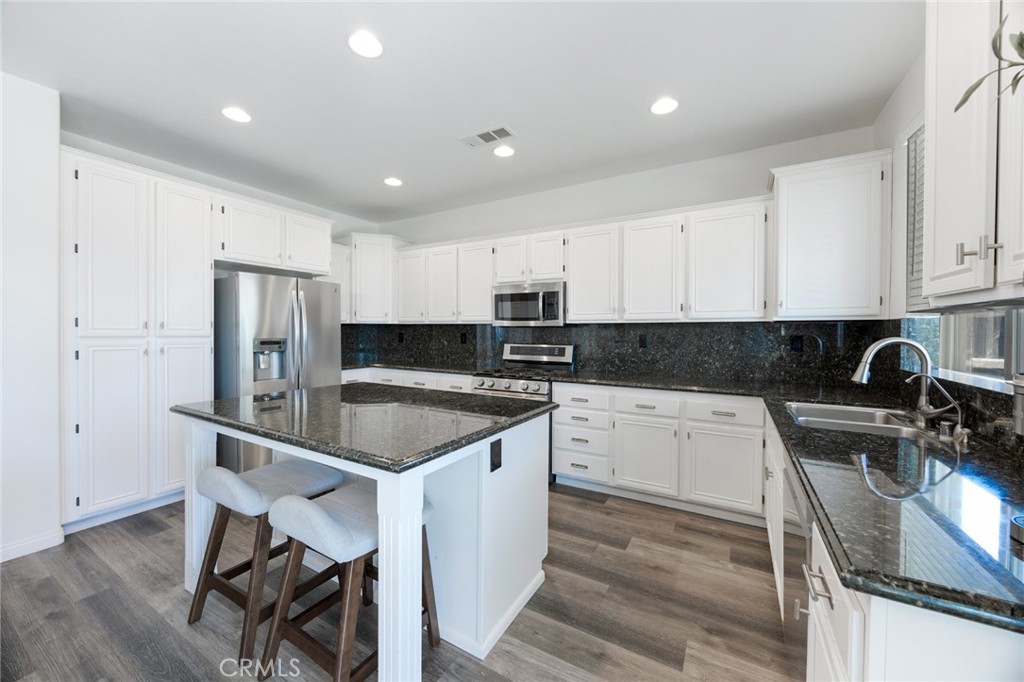 33345 Wallace Way Yucaipa, CA 92399 - Photo 15 of 38 a kitchen with stainless steel appliances granite countertop a sink refrigerator and cabinets