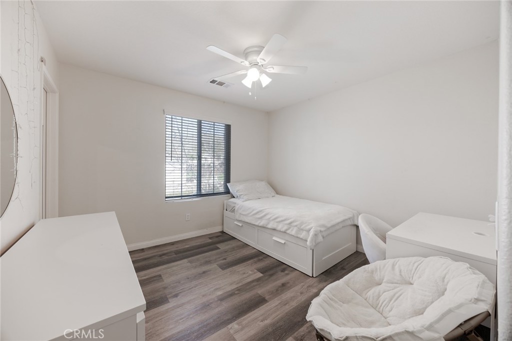 33345 Wallace Way Yucaipa, CA 92399 - Photo 30 of 38 a spacious bedroom with two beds and a chandelier