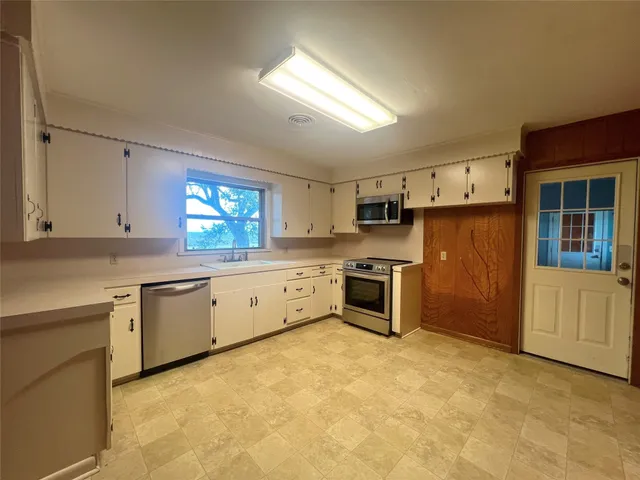 a kitchen with a sink stove and refrigerator