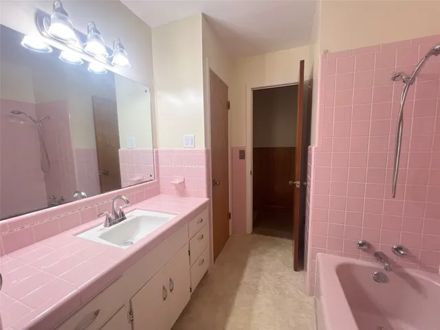 a bathroom with a sink double vanity granite tub shower and a mirror
