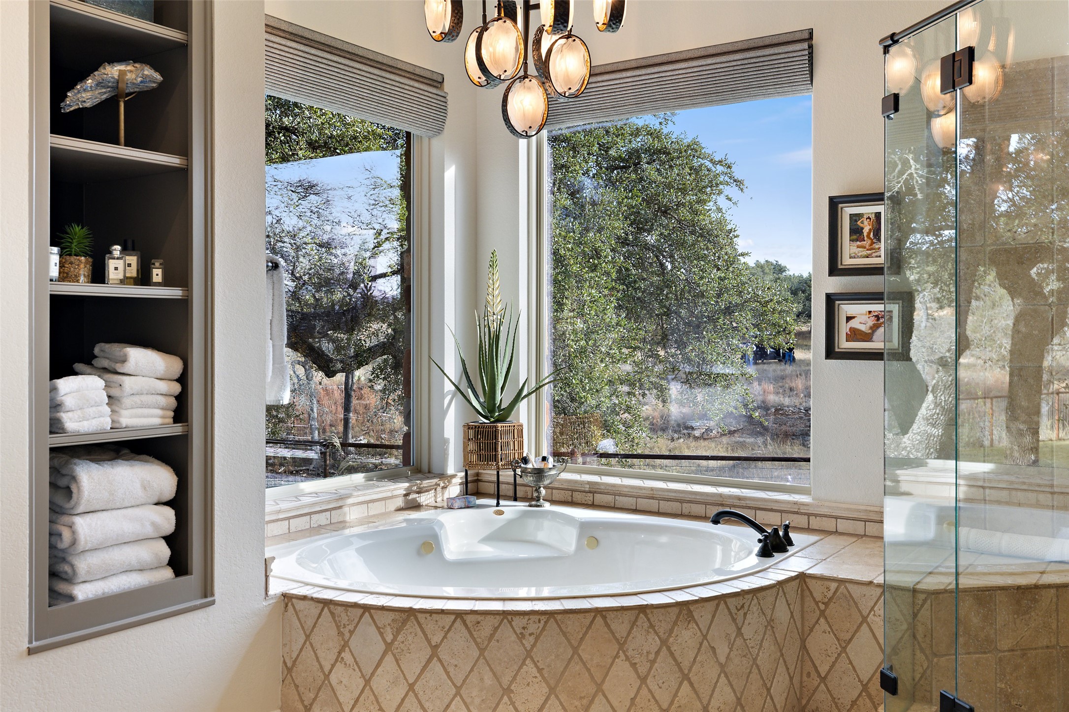 751 Prochnow Road Dripping Springs, TX 78620 - Photo 15 of 40 Bathroom with a relaxing tiled tub, an inviting chandelier, and built in features