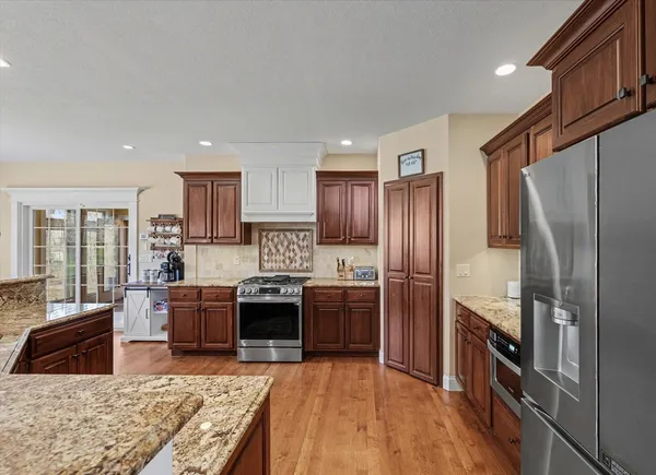 a kitchen with stainless steel appliances granite countertop a refrigerator stove and sink