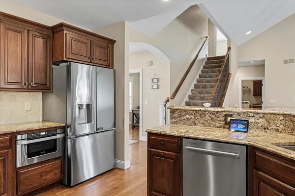 a kitchen with stainless steel appliances granite countertop a refrigerator and a sink