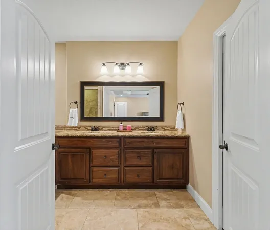 a bathroom with a granite countertop sink and a mirror