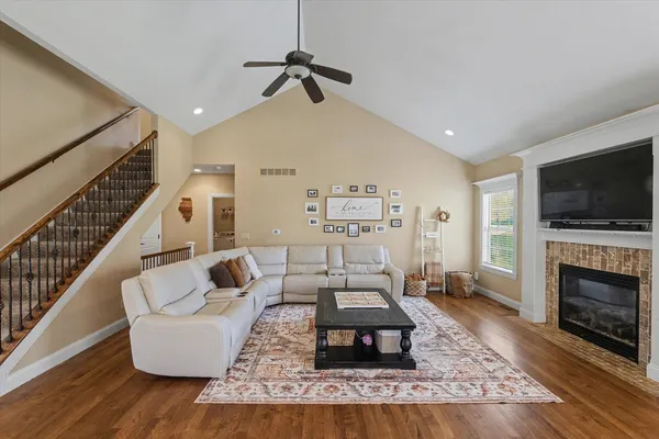 a living room with furniture a flat screen tv and a fireplace