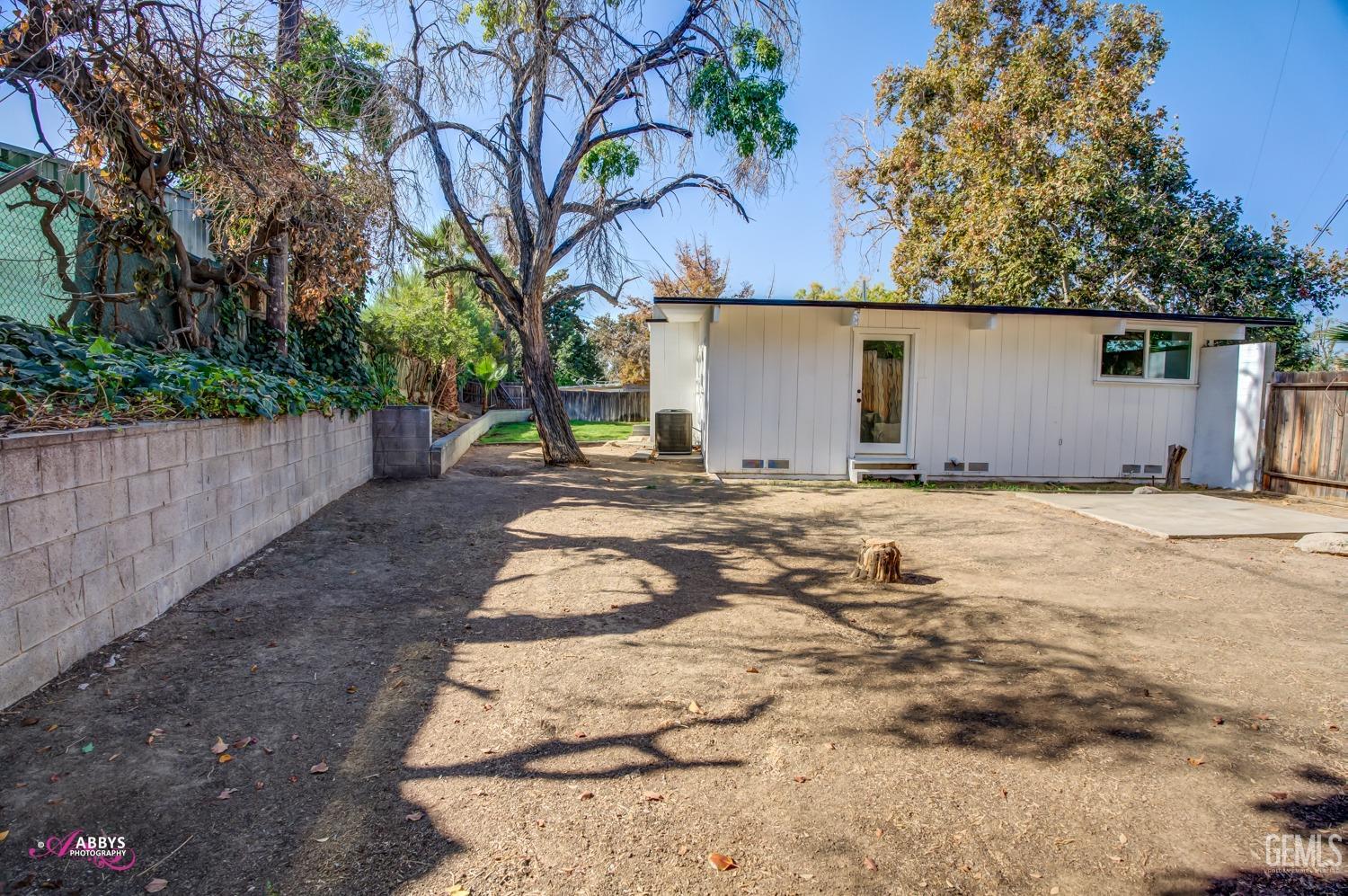 Undisclosed Address Bakersfield, CA 93306 - Photo 12 of 32 a backyard of a house with large trees and wooden fence