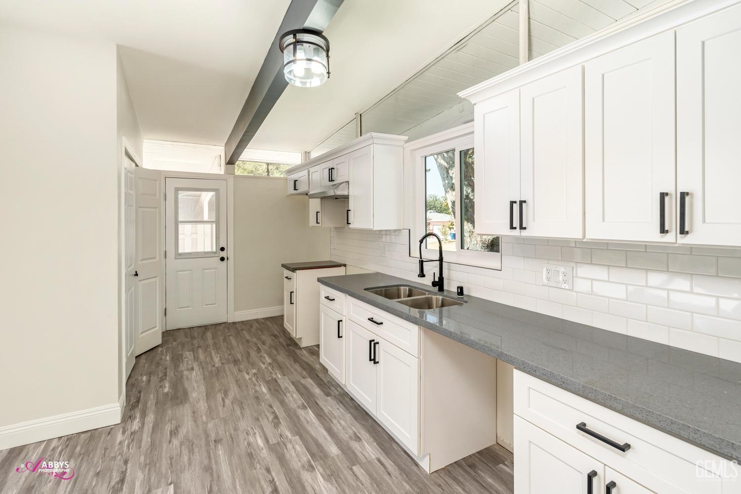 Undisclosed Address Bakersfield, CA 93306 - Photo 29 of 32 a kitchen with granite countertop a sink cabinets wooden floor and stainless steel appliances