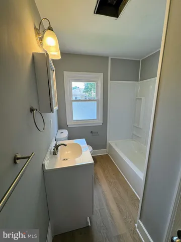a bathroom with a sink a tub and mirror