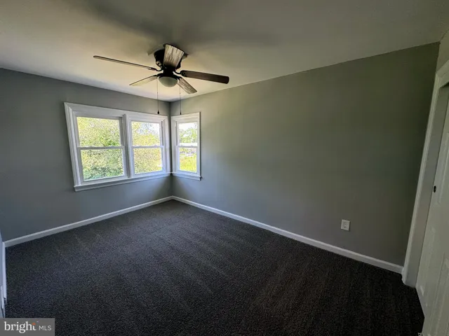 an empty room with a window and a ceiling fan