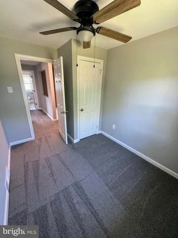 a view of a big room with wooden floor and windows