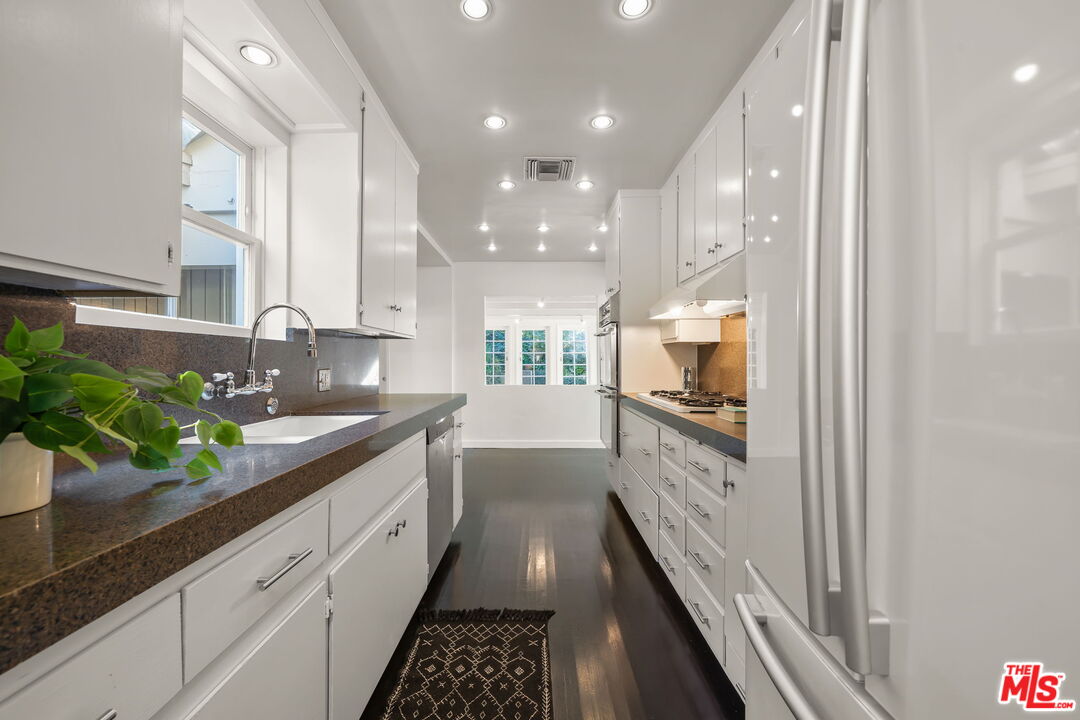3621 Longview Valley Road Sherman Oaks, CA 91423 - Photo 7 of 25 a large kitchen with granite countertop a large counter top a sink and stainless steel appliances